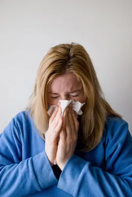 woman sneezing with symptoms affecting the nose