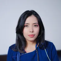 Female healthcare provider wearing blue scrubs in a clinical setting