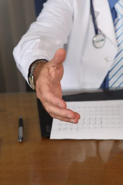 Doctor’s hand holding a clipboard during a medical consultation