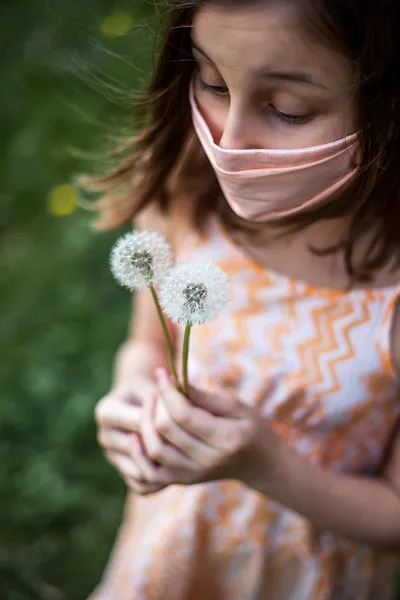 Girl experiencing allergy symptoms while standing outdoors